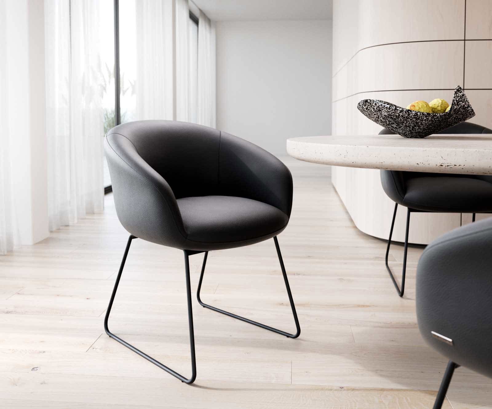 Chaise-de-salle-à-manger Vinka-Flex avec accoudoirs cuir de vache noir pied trapèze noir ressorts ensachés Chaise-de-salle-à-manger Vinka-Flex avec accoudoirs cuir de vache noir pied trapèze noir ressorts ensachés