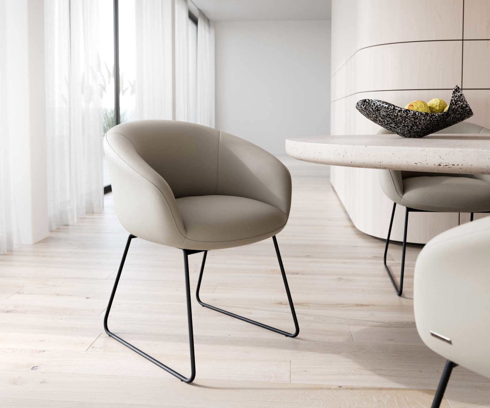 Chaise-de-salle-à-manger Vinka-Flex avec accoudoirs cuir de vache couleur boue pied trapèze noir ressorts ensachés Chaise-de-salle-à-manger Vinka-Flex avec accoudoirs cuir de vache couleur boue pied trapèze noir ressorts ensachés