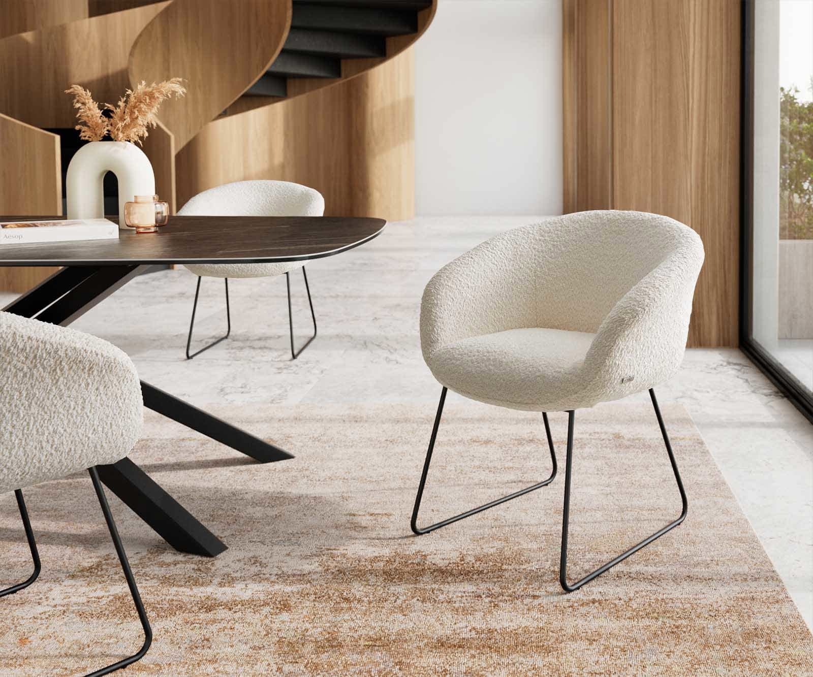 Chaise-de-salle-à-manger Vinka-Flex avec accoudoirs bouclé blanc pied trapèze noir ressorts ensachés Chaise-de-salle-à-manger Vinka-Flex avec accoudoirs bouclé blanc pied trapèze noir ressorts ensachés