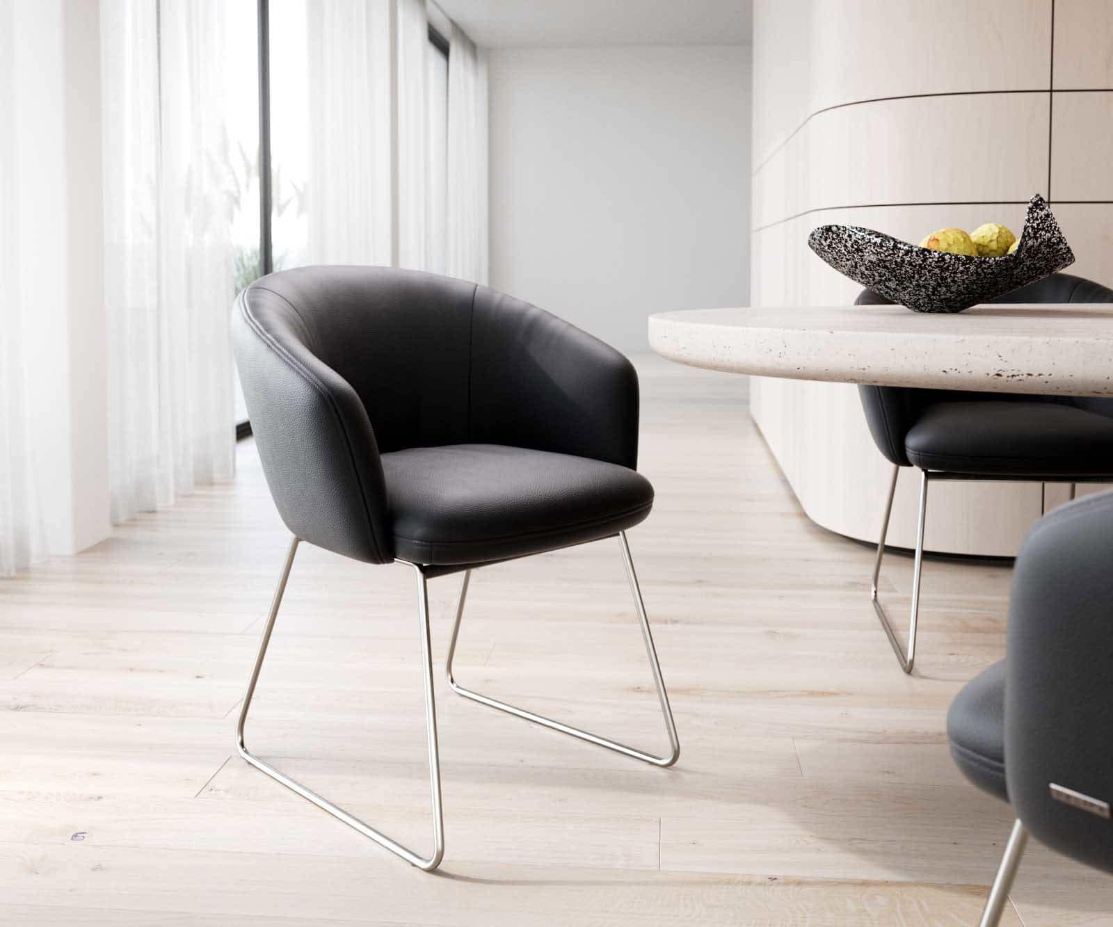 Chaise-de-salle-à-manger Caja-Flex avec accoudoirs cuir de vache noir pied trapèze acier inoxydable brossé ressorts ensachés Chaise-de-salle-à-manger Caja-Flex avec accoudoirs cuir de vache noir pied trapèze acier inoxydable brossé ressorts ensachés