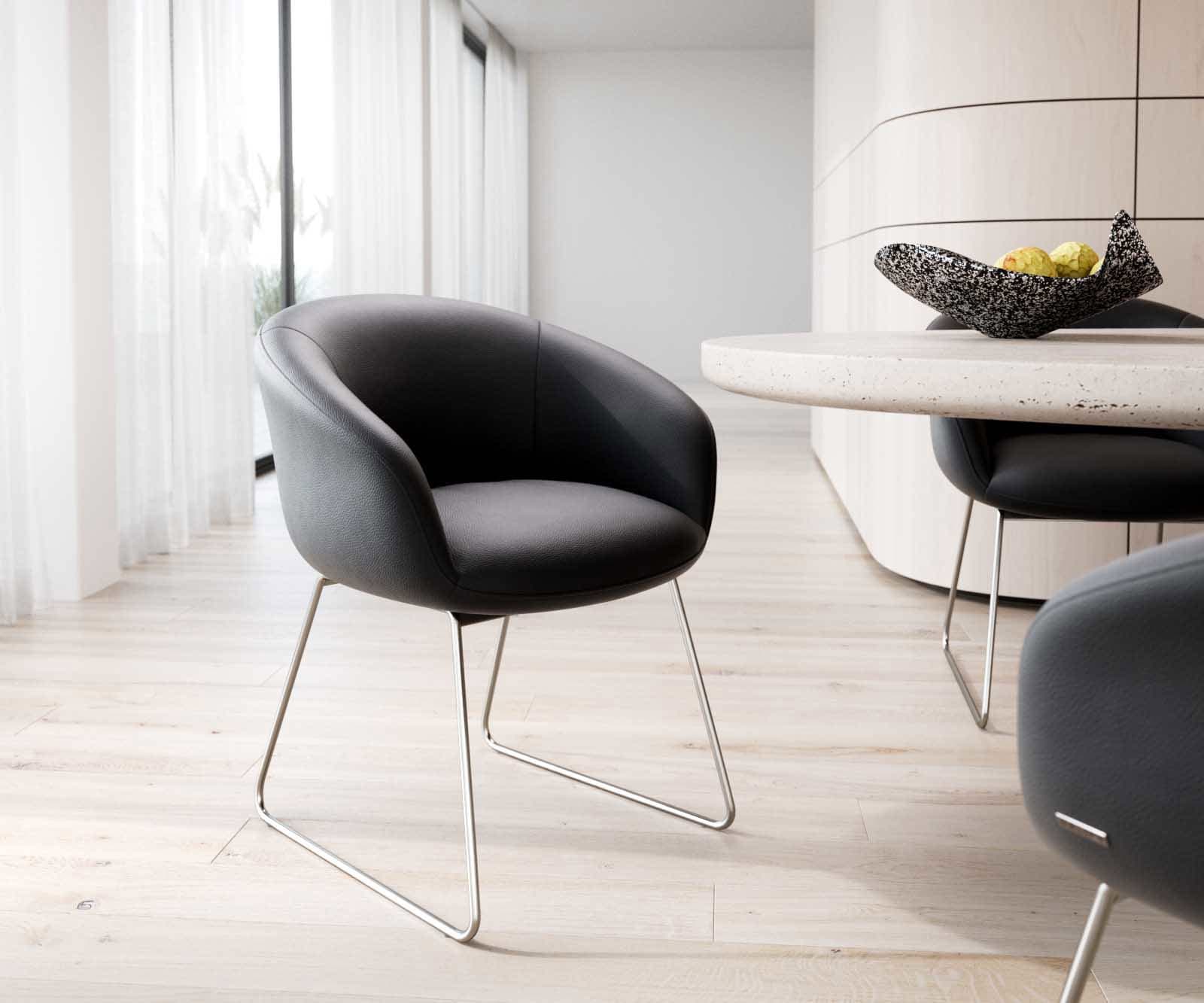 Chaise-de-salle-à-manger Vinka-Flex avec accoudoirs cuir de vache noir pied trapèze acier inoxydable brossé ressorts ensachés Chaise-de-salle-à-manger Vinka-Flex avec accoudoirs cuir de vache noir pied trapèze acier inoxydable brossé ressorts ensachés